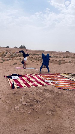 Pratique yoga au lever du soleil lors de la retraite yoga dans le désert marocain